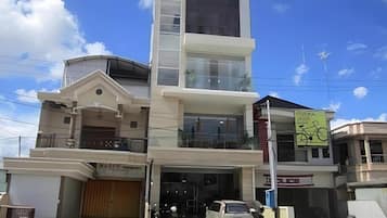 A multi-story building with a garage entrance, a visible signboard, and a clear sky.