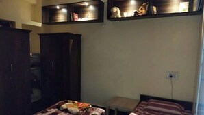 Un dormitorio con dos camas, una mesita y un armario.
