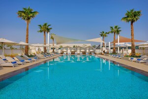 Una piscina al aire libre, camas de piscina gratis, sombrillas
