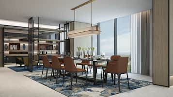 A modern dining area with a large table, chairs, and a hanging light fixture.