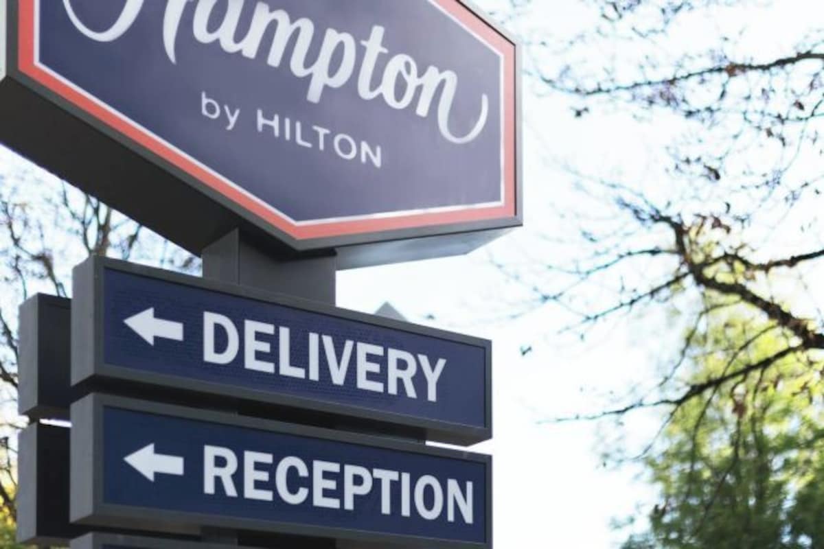 Señal de hotel con indicaciones hacia entrega de paquetes y recepción.