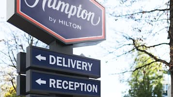 Un letrero de hotel que indica las direcciones para entrega, recepción y estacionamiento.