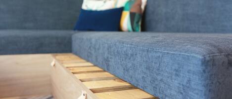 Un sofá modular con base de madera y cojines de colores.