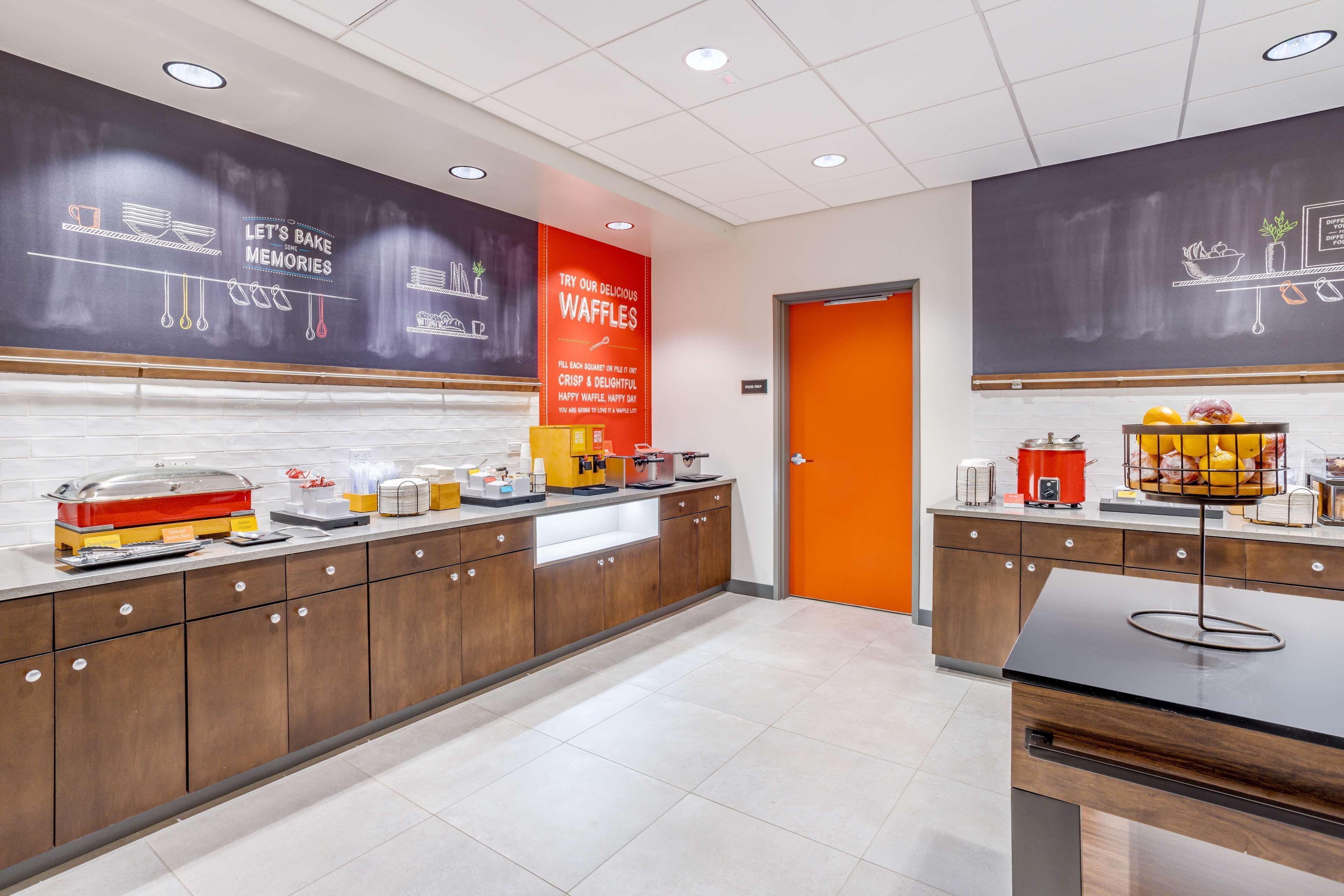 Een moderne keuken met een buffetopstelling, waaronder een presentatie van wafels en diverse etenswaren.