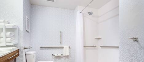 A modern bathroom with a toilet, shower, and sink.