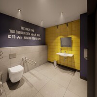 Un baño moderno con inodoro, lavamanos y barras de apoyo.