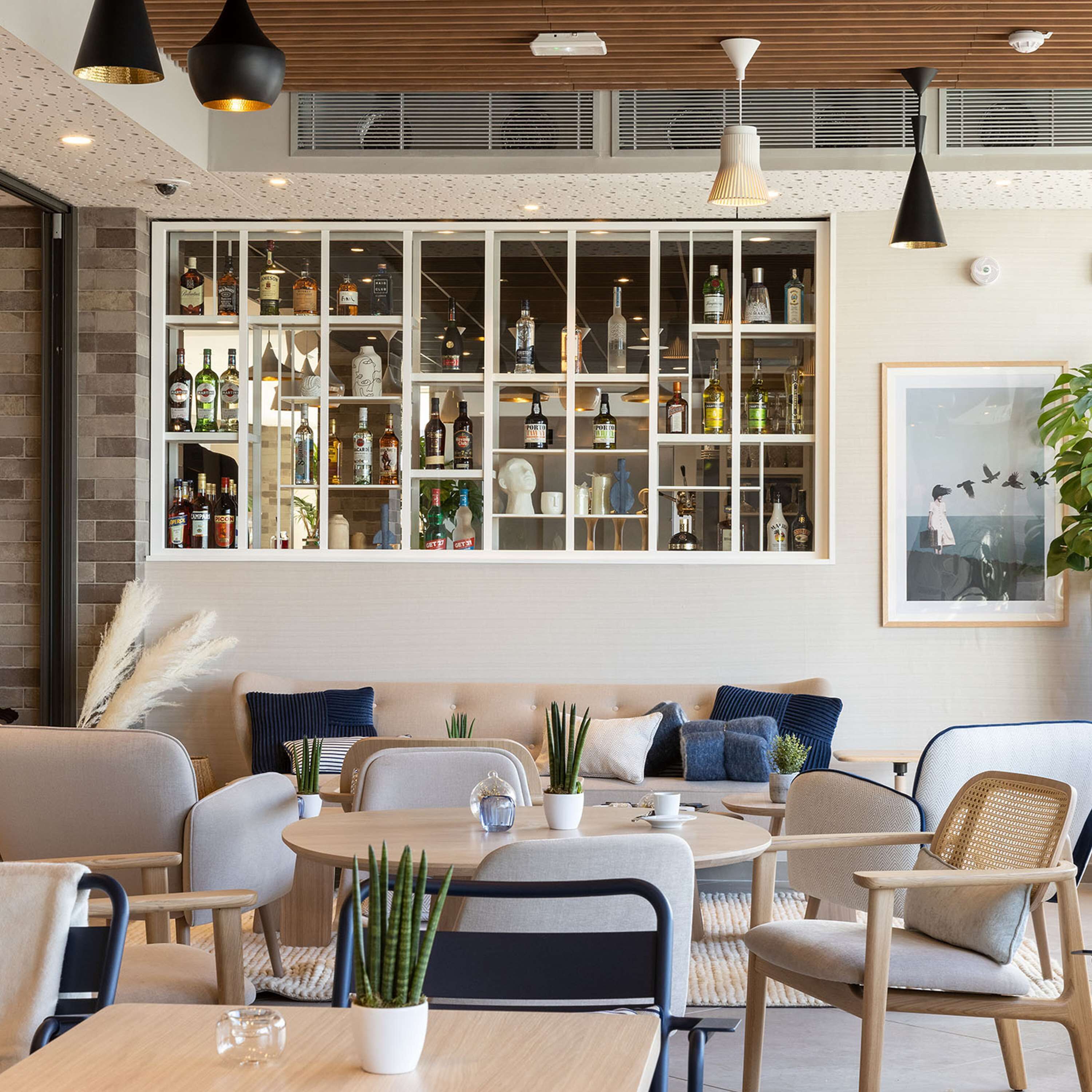 Un salon moderne doté d’une grande fenêtre, d’un bar intégré et d’un coin repas.
