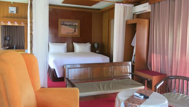Una habitación de hotel con cama, una silla, una mesita y un escritorio con silla.