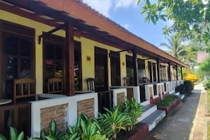 Stunning two-story building with a charming facade, surrounded by lush gardens and outdoor seating areas.