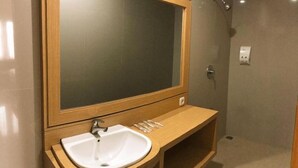 Une salle de bain avec un meuble-lavabo en bois, un évier et un miroir.