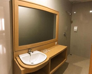 Une salle de bain avec un meuble-lavabo en bois, un évier et un miroir.