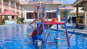 A swimming pool with a blue tiled floor, surrounded by a building labeled 'FITNESS CENTRE'.