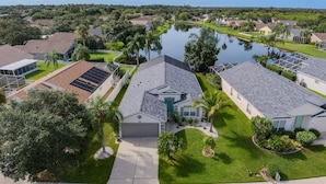 A residential area with houses, a lake, and a well-maintained lawn. - Turtle Lake - Inspiring Lake Views with Heated Pool by The Bay & Key Collection (Bradenton)