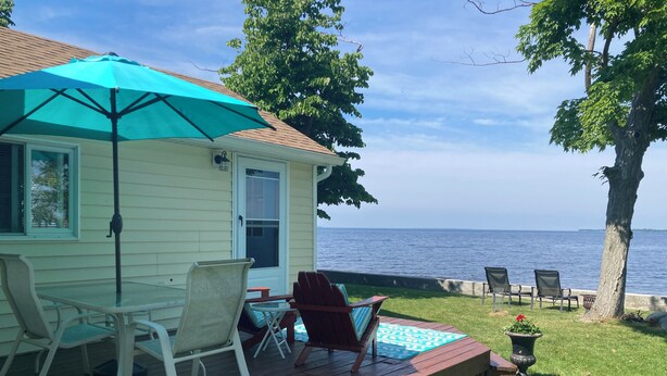 A deck with outdoor furniture, a turquoise umbrella, and a view of the sea. - Sunset Cottage on Pillar Point (Dexter)