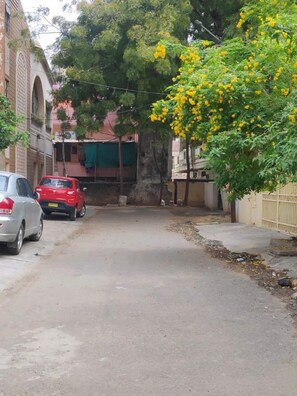Stroll through a quiet residential street lined with parked cars.