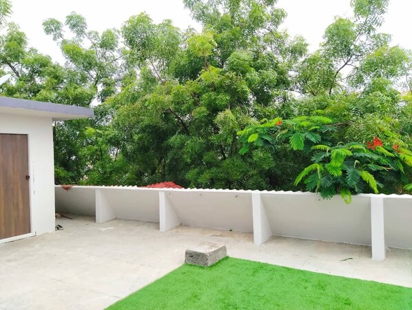 Enjoy the serene atmosphere of this outdoor space with a lush lawn and beautiful trees.