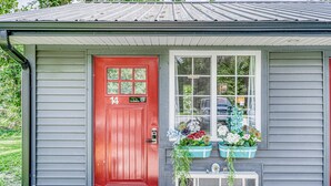 A house with a red door, number 14, and a window with flower baskets. - Lighthouse Inn & Suites Extended Stay
Boutique Hotel I-69 Exit 334 (Waterloo)