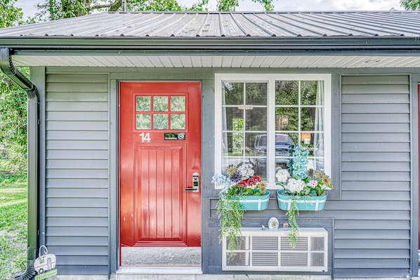 A house with a red door, number 14, and a window with flower baskets. - Lighthouse Inn & Suites Extended Stay
Boutique Hotel I-69 Exit 334 (Waterloo)