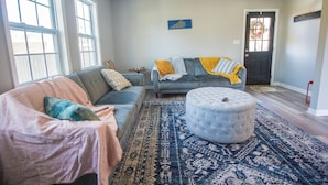 A living room with a sofa, ottoman, and a patterned rug. - Heart of the Bluegrass close to all attractions in Central Kentucky (Lexington)