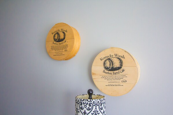 Two circular wooden plaques with Kentucky Woods Bourbon Barrel Cake branding, mounted on a wall.