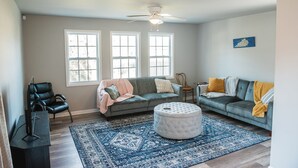 A living room with two sofas, a coffee table, a TV, and a ceiling fan. - Heart of the Bluegrass close to all attractions in Central Kentucky (Lexington)