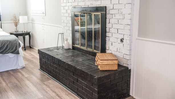 A room with a black brick fireplace, a white-framed mirror, and a wicker basket on the mantel. - Heart of the Bluegrass close to all attractions in Central Kentucky (Lexington)