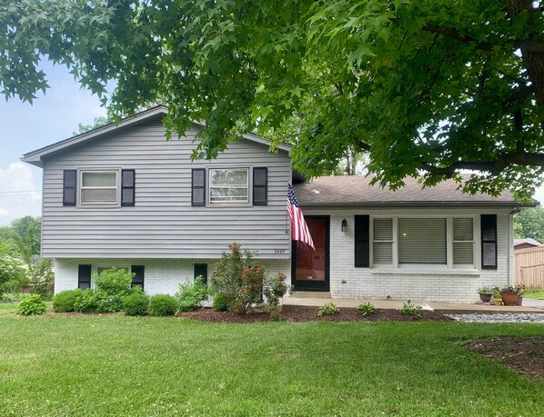 A two-story house with a front porch, a small front yard, and an American flag. - Heart of the Bluegrass close to all attractions in Central Kentucky (Lexington)