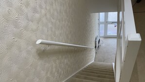 A staircase with a textured wall and a handrail. - Cheerful 3 Bedroomed house,with parking and free intern free (Luton)