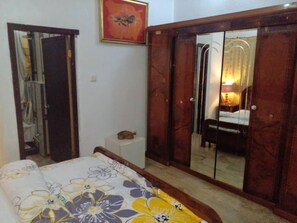Une chambre à coucher avec un lit, une armoire et un miroir.