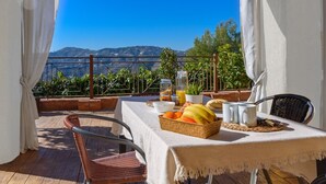 A table set with fruits and a drink, overlooking a scenic view. - Villa María del Carmen Frigiliana by Ruralidays (Málaga)