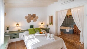 A well-lit bedroom with a bed, bedside table, and a view of a bathroom. - Villa María del Carmen Frigiliana by Ruralidays (Málaga)