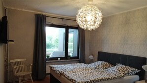 Une chambre à coucher avec un lit, une chaise, une fenêtre et un lustre.