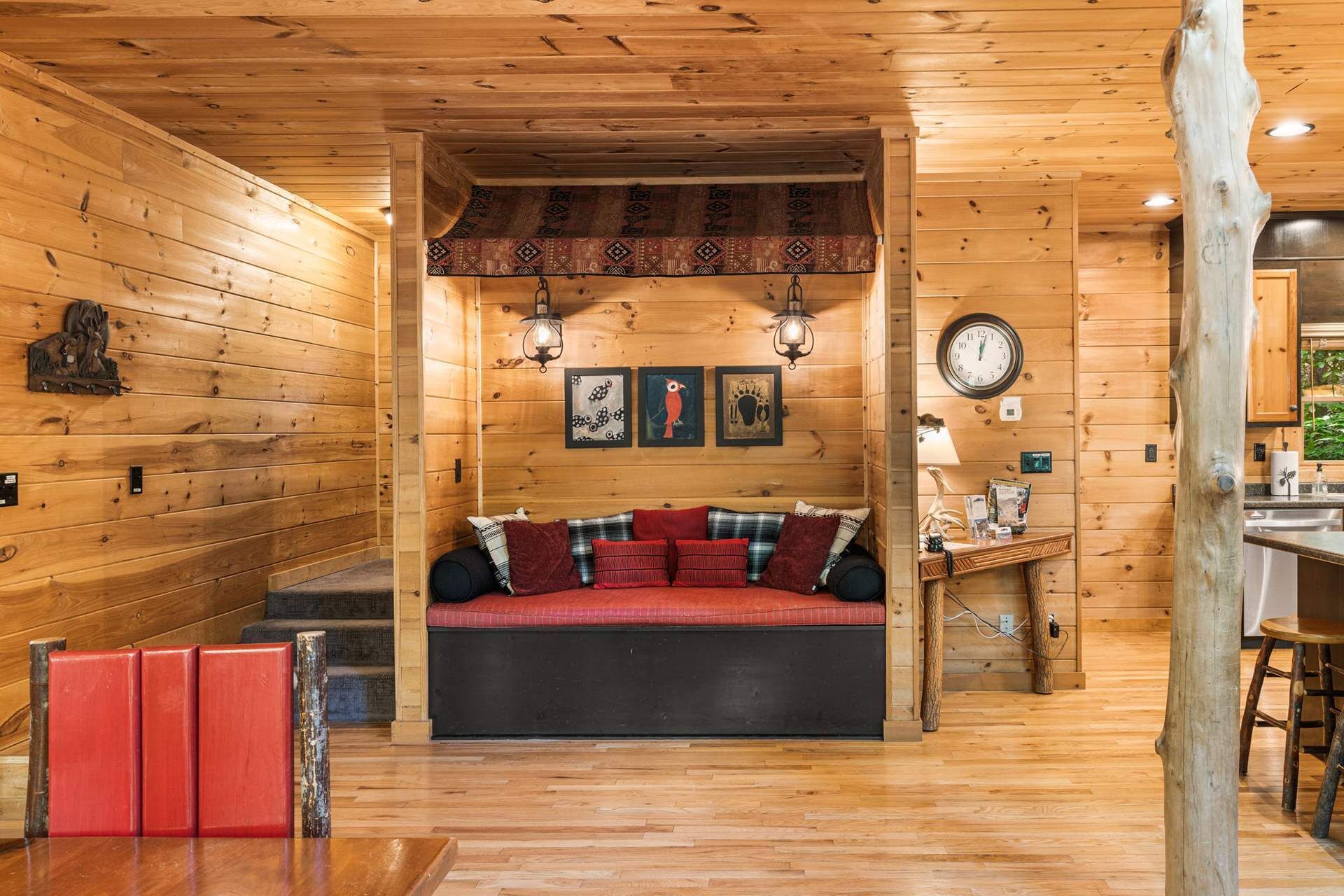 A cozy cabin interior with a wooden bench, wall-mounted clock, and rustic decor.