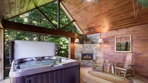 A wooden cabin with a hot tub, stone fireplace, and rustic furniture. - Hot Tub & Scenic Mountain Views, Game Room (Mineral Bluff)