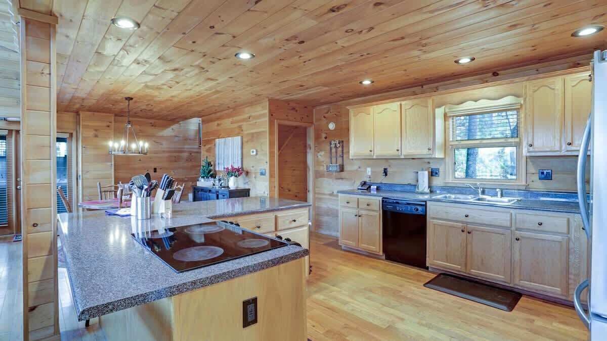 A spacious kitchen with wooden cabinets, a granite countertop, and a built-in stove.