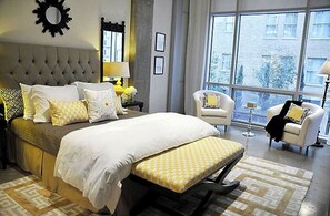 Relax in a spacious room with a large bed, comfortable seating area, and a view of the outside.