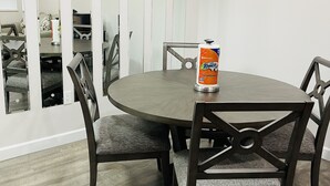A conference room with a round table, four chairs, and a can of Towels on the table.