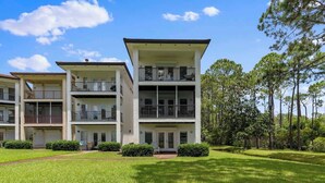 A multi-story residential building with balconies, surrounded by well-maintained lawns and trees. - Fall in Love with Florida!-Now at Reduced Rates (Santa Rosa Beach)