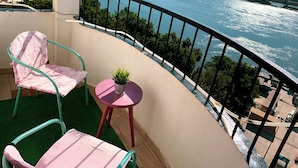 A balcony with two chairs and a small table, overlooking a river with a cityscape in the background. -  Nile & Pyramid View – Magical Sunrises, Historic Wonders (Cairo)