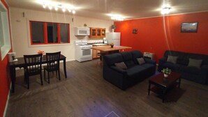 A compact living space with a dining area, kitchenette, and seating area.