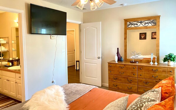 A bedroom with a bed, dresser, mirror, and television. - Spacious & comfy home in ultra-convenient location (Winder)