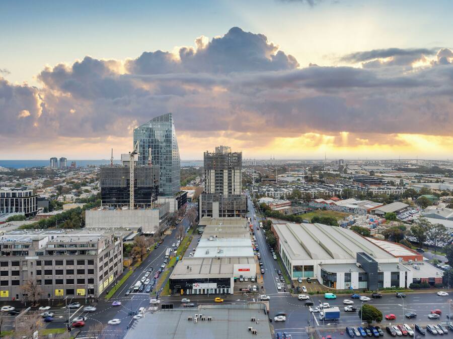 Une vue urbaine avec des bâtiments modernes, un grand parking et un ciel dégagé.