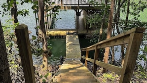 A wooden bridge leading to a dock over a body of water, surrounded by trees. - Lakeview Home/Private Boat Dock/Hot tub/Golf Cart/Gameroom/Stunning Fall Views (LaFollette)