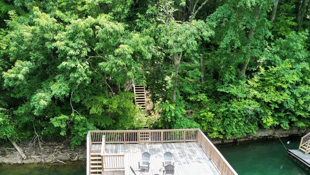 A wooden deck with seating and a sign for 'RENT ME!'. - Lakeview Home/Private Boat Dock/Hot tub/Golf Cart/Gameroom/Stunning Fall Views (LaFollette)