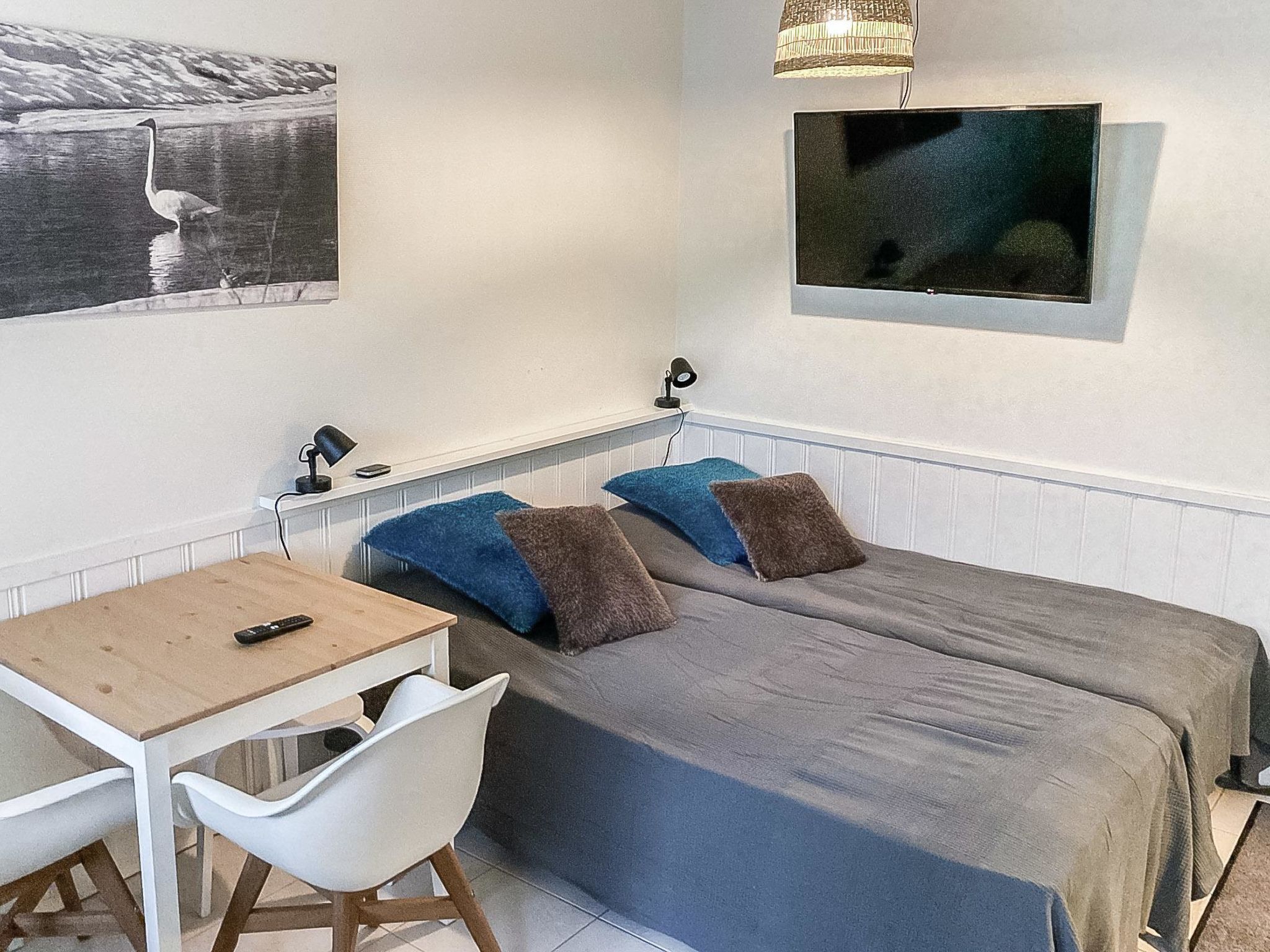 A bedroom with two beds, a desk, and a chair.