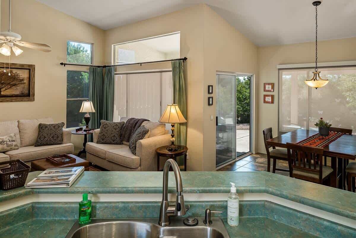 A living area with a sofa, a coffee table, a lamp, and a dining table with chairs.