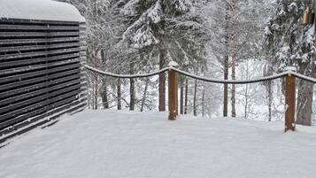 A snow-covered outdoor area with a wooden fence and a rope barrier.