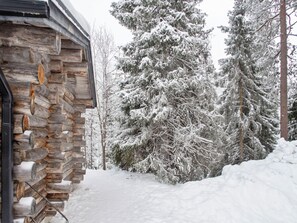 A stone building with a snow-covered landscape and trees.