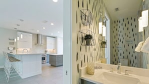 A modern kitchen with a central island, built-in appliances, and a dining area with white chairs. - White Pearl - Modern Vacation Rental House in Destiny by the Sea with Shared Pool (Destin)