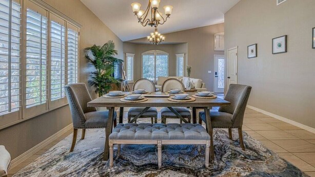 A dining room with a large wooden table set for six, surrounded by six chairs. - Casa Del Arbol Outdoor Oasis (El Paso)